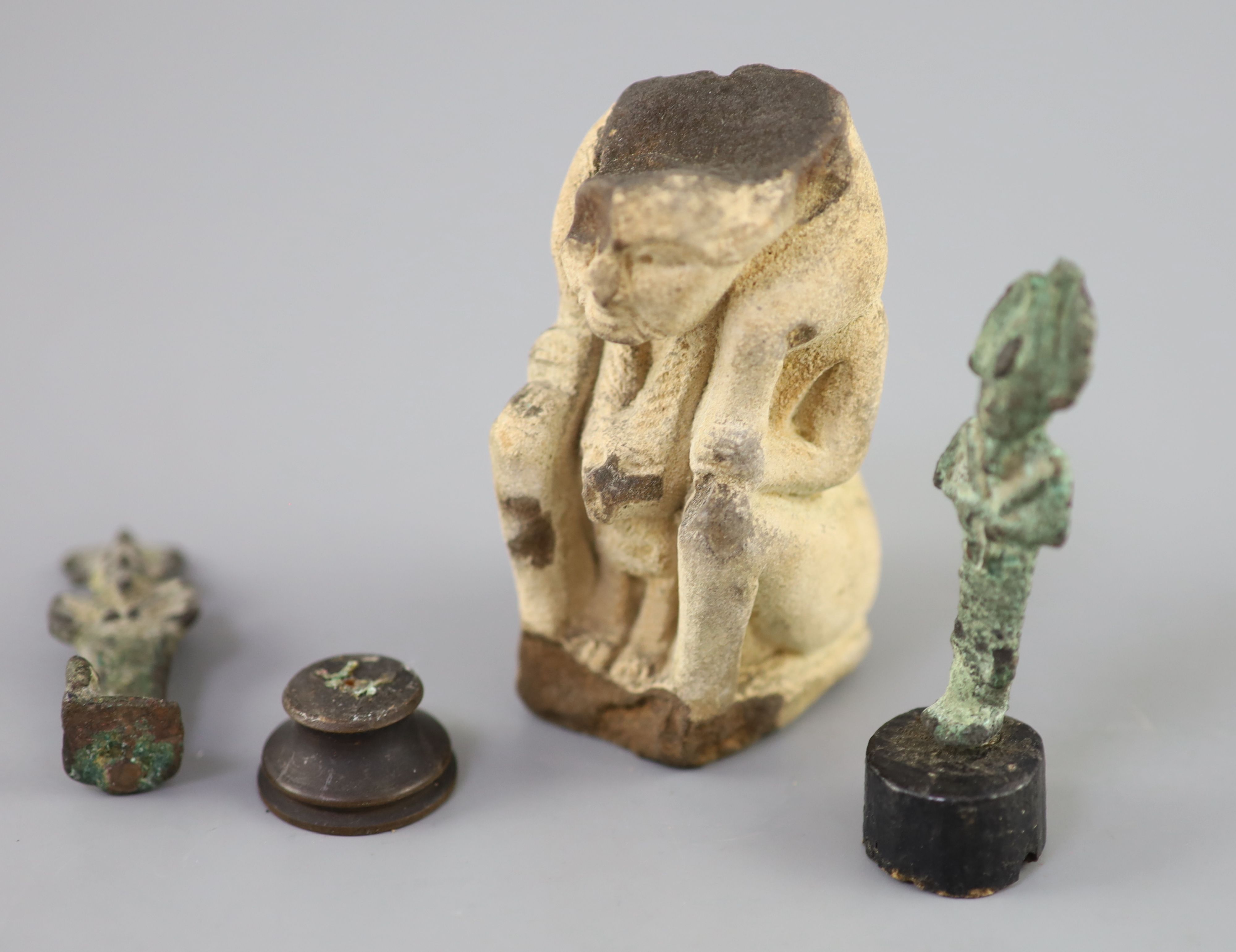 Two Egyptian bronze statuettes of Osiris and a sculpted limestone figure fragment, Ptolemaic period, Provenance - A. T. Arber-Cooke